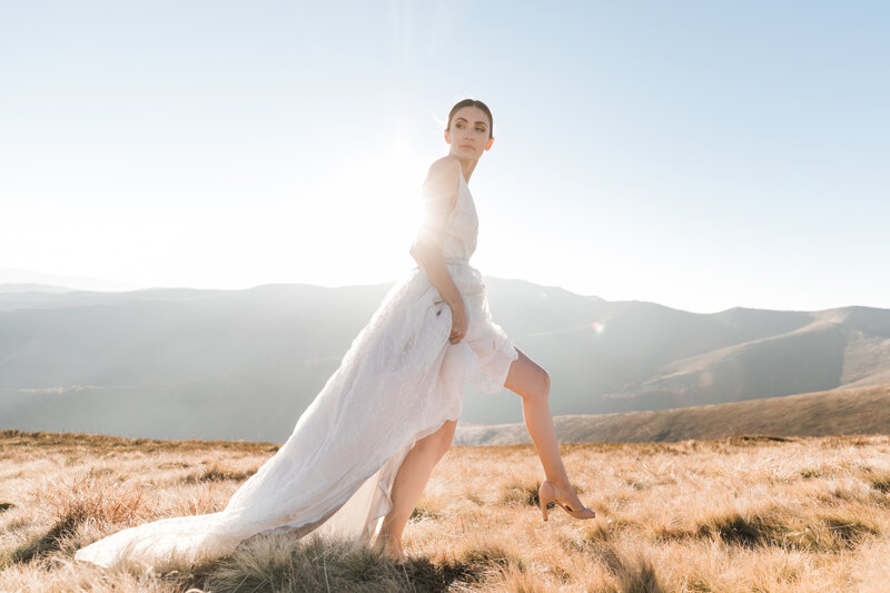 Wedding photography portfolio in Italy: Bride in a wedding dress on a background of mountains lit by the sun