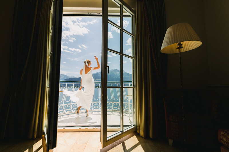 Wedding photography portfolio in Italy: Photo from the room of the Bride, who is in a white dress with a veil, stands on the balcony of a luxury villa on the shores of Lake Como