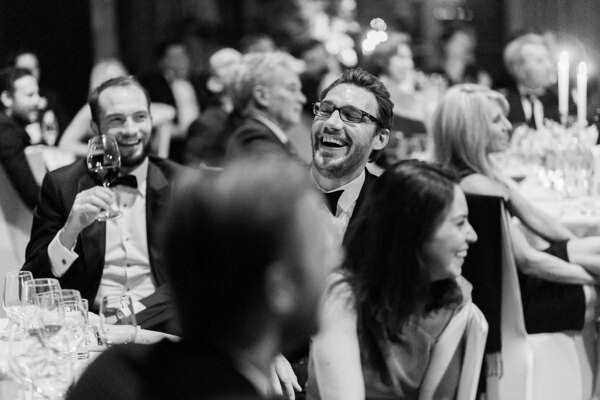 Destination Wedding Photographer in Italy: Cheerful guests joyfully smile at the table
