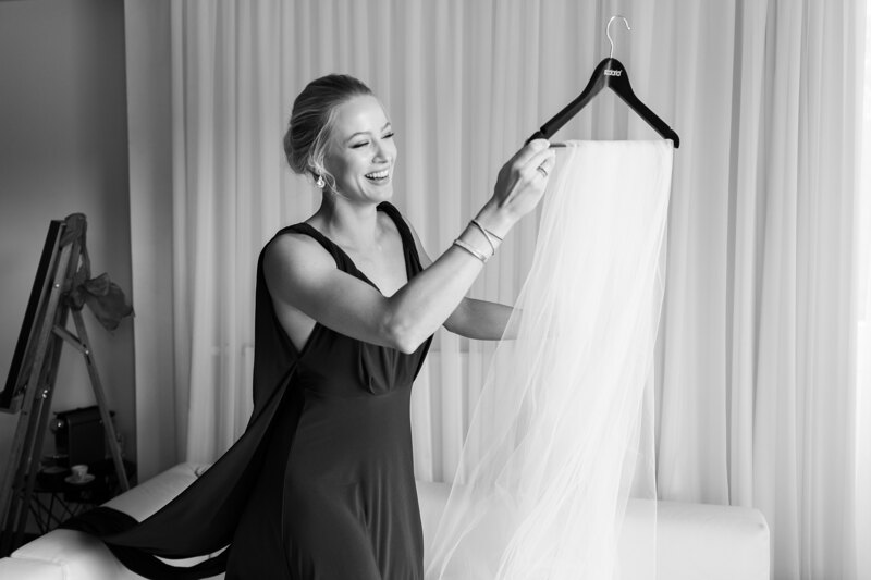 Wedding photography portfolio in Italy: Girlfriend of the bride carries a veil to dress her bride