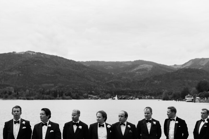 Wedding photography portfolio in Italy: Photo of friends of the groom at an exit ceremony on a background of mountains and a lake