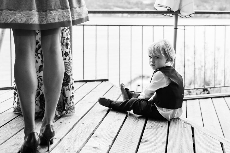 Wedding photography portfolio in Italy: A boy in a suit sits on the hotel porch