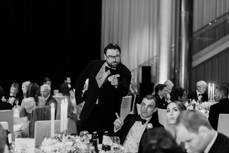 Wedding photography portfolio in Italy: One of the guests says a toast at a wedding and demonstrates something on camera
